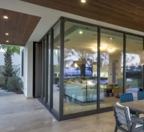 Impact sliding glass doors opening a living room to a covered pool lanai